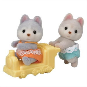 Two toy cats with a yellow toy train on a white background