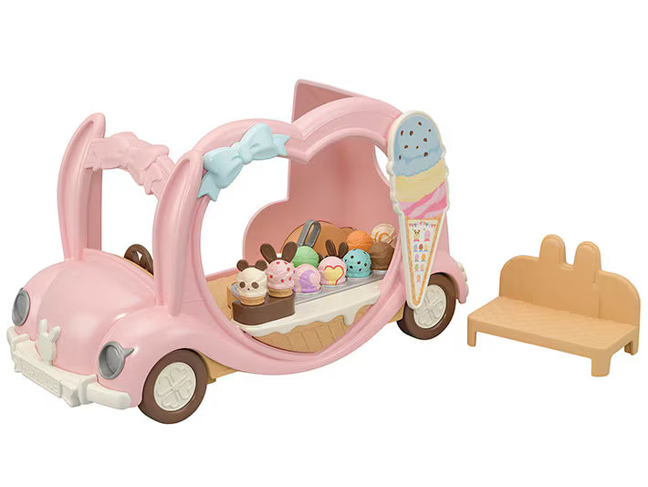 Toy ice cream cart with various treats and a small table on a white background