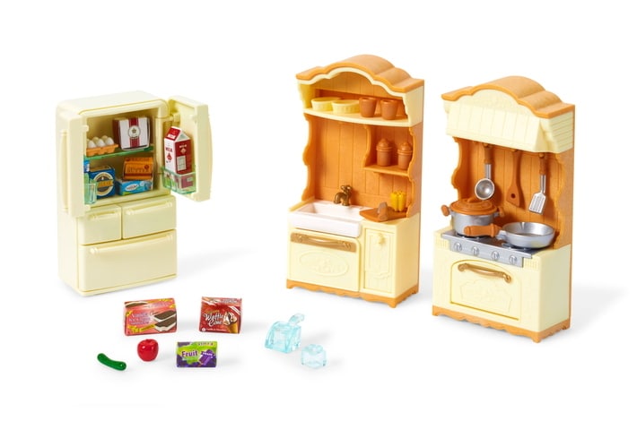 Toy kitchen set with refrigerator, sink, and stove on a white background