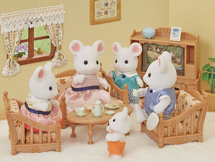Toy mouse family in a living room setting with furniture and decor.