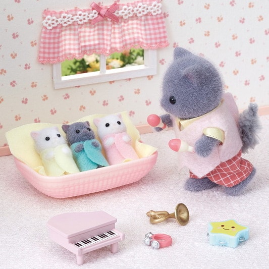 Toy scene with plush toys in a room setting, including a piano and window.