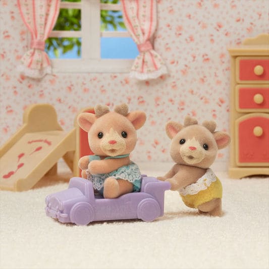Two toy figures of a mouse and a rabbit sitting on a purple couch in a room with pink furniture and wallpaper.